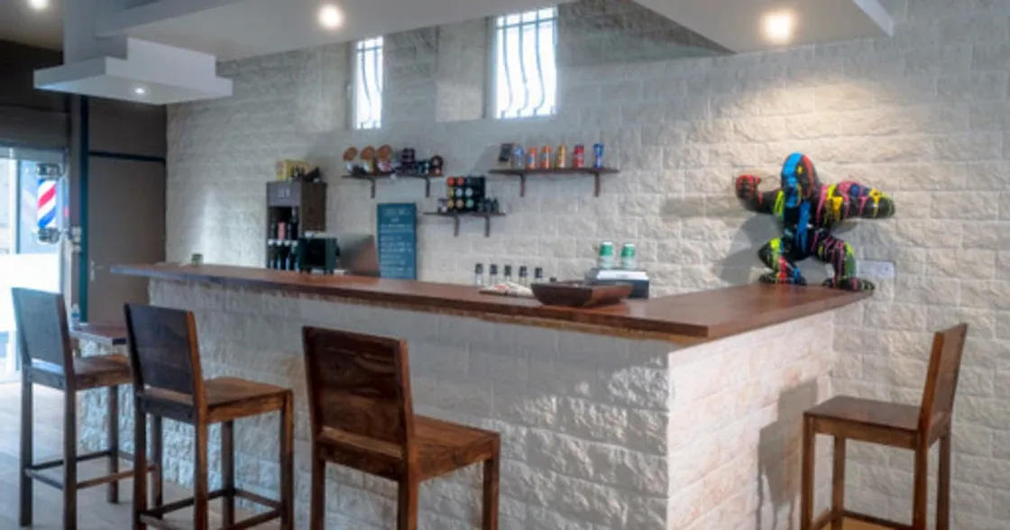 Comptoir du salon Barber Bink's avec pierre claire et finitions bois.
